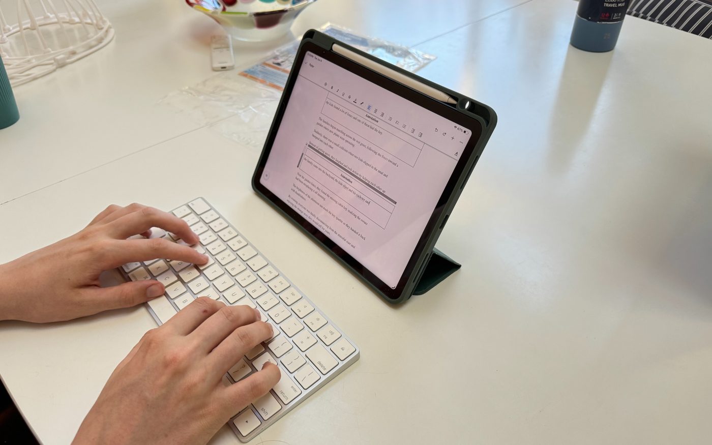 Student typing beside a digital worksheet on an iPad